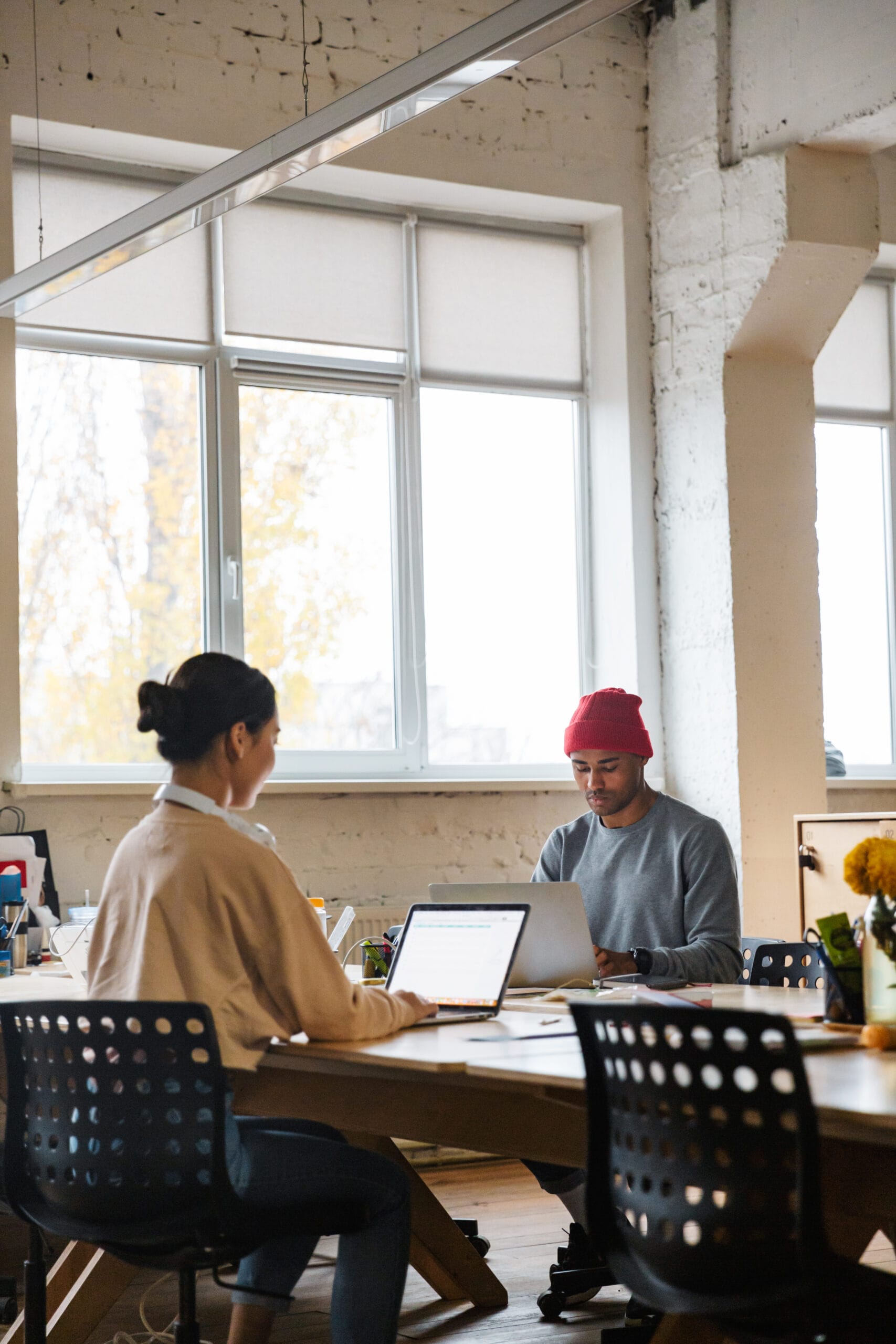 Image of multiethnic young coworkers working on laptops in offic